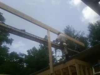 Carpenter setting a ridge beam over a new addition frame — Ice Dam Removal by Roofing Brothers in Hartsdale