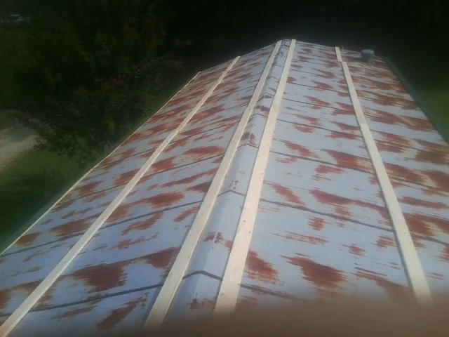 Rusted metal roof panels with new wood purlins before replacement — Storm Damage Roof Repair in Hartsdale by Roofing Brothers