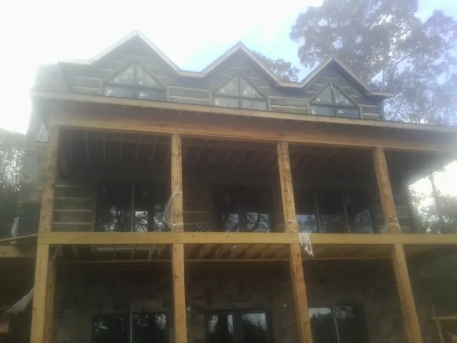 Dormers and porch framing on a large log home under construction — Roof Coating work by our crew in Hartsdale
