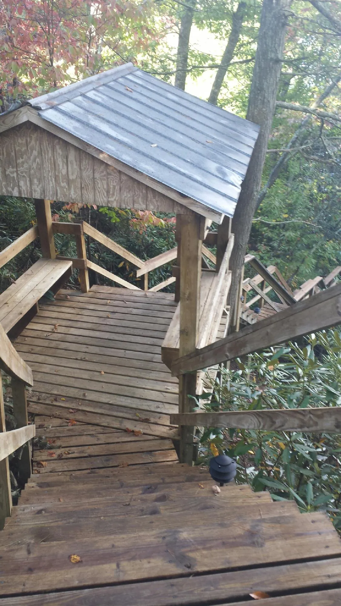 Metal roofed shelter over wooden steps on a wooded walkway — Skylight Repair & Installation work by our crew in Hartsdale